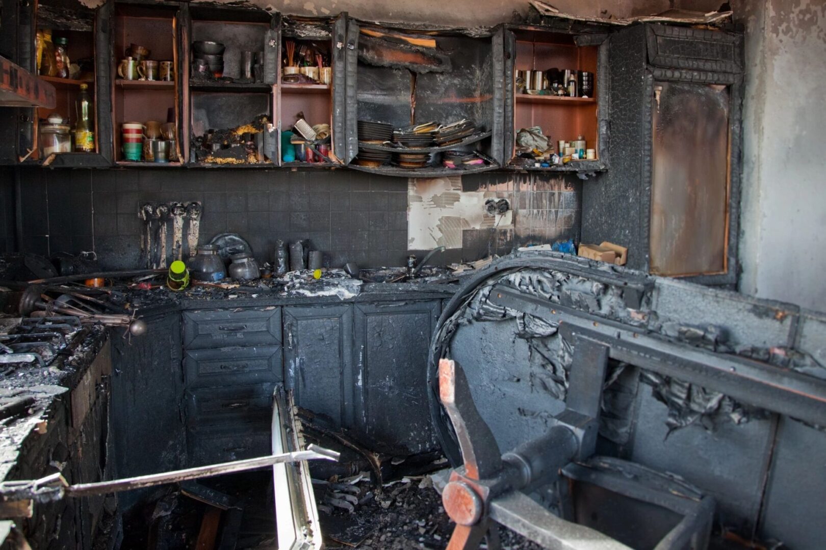 A kitchen with black paint and fire damage.